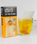 Box of Disposable Loose Leaf Tea Filters For Easy Brewing with glass cup of tea, unbleached paper sachet visible, 100 empty bags.