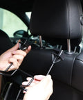 Installing Dual Hook Hard Hat Holder for Truck Seats and Car Back Seats on car headrest, black heavy-duty hooks for organization.