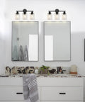 Modern bathroom with double mirrors, decorative lighting, and a stylish countertop arrangement.