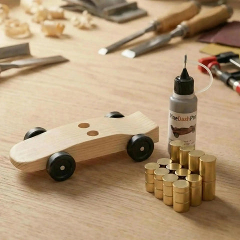 Copper Pinewood Derby Weights Kit Must Have With Three Sizes One Quarter Ounce One Eighth Ounce One Sixteenth Ounce Four Point Five Ounces Plus Graphite Powder Lubricant Anti Tarnish Coated For Derby Car Wheels And Axles, showing wooden derby car with weights and lubricant bottle on a table.