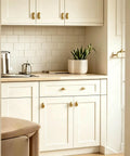 Top Shelf Brushed Brass Oval Cabinet Knobs And Zinc Alloy Single Hole Drawer Pulls Featuring Warm Olive Tones Four Pack on white kitchen cabinets.