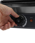 Hand adjusting temperature control dial on 1800W Commercial Panini Grill Press With Stainless Steel Body And Cast Iron Plates.