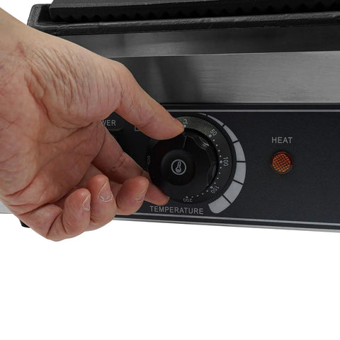 Hand adjusting temperature control dial on 1800W Commercial Panini Grill Press With Stainless Steel Body And Cast Iron Plates.