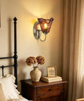 Vintage Glass Wall Sconces Set of 2,Aged Brass Bathroom Vanity Lighting with amber glass shade beside a bedside table.