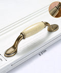 Eight Piece Ceramic Drawer Handles Set In Chinese Style With Vintage Antique Design on white cabinet, close-up of beige grip.