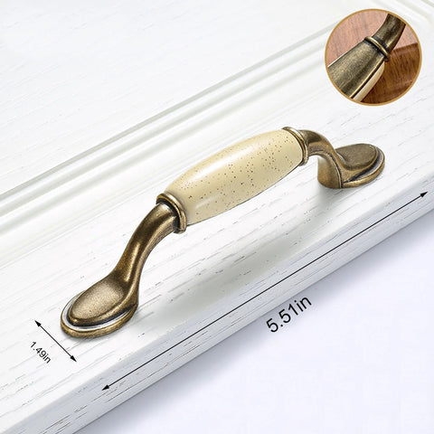 Eight Piece Ceramic Drawer Handles Set In Chinese Style With Vintage Antique Design on white cabinet, close-up of beige grip.