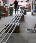 Game Changer Light Duty Roller Conveyor Table Featuring Hella Durable Abs Plastic Rollers and a Foldable Skate Flow Rack Design in use with boxes.