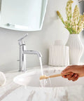 Person using a toothbrush under Gibson One Handle Single Hole Modern Bathroom Sink Faucet With Optional Deck Plate In Chrome Finish