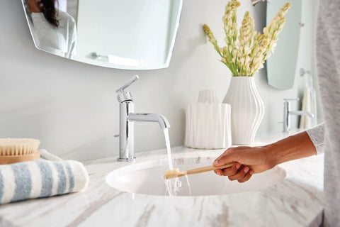 Person using a toothbrush under Gibson One Handle Single Hole Modern Bathroom Sink Faucet With Optional Deck Plate In Chrome Finish