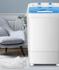 Compact Portable Washing Machine With 7.5 Liter Basin For Quick Laundry And Sneaker Scrubs next to white sneakers on a carpet.