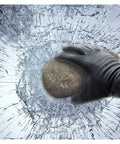 Gloved hand holding rock against cracked glass demonstrating Window Film For Security And Safety 4 Mil Clear Roll 36 Inch By 24 Foot Interior Application Absorbs Impact And Holds Shattered Glass To Prevent Break Ins ANSI Z97.1 Class B And CPSC Category 1 Compliant Ideal For Homes And Offices.