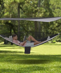 Man reading in Heavy Duty Camping Hammock With Rain Fly Tarp And Mosquito Net 440 Lb Capacity Portable Tree Hammock in forest
