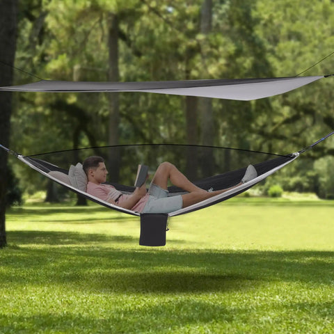Man reading in Heavy Duty Camping Hammock With Rain Fly Tarp And Mosquito Net 440 Lb Capacity Portable Tree Hammock in forest