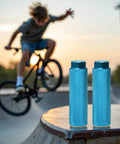 Two Pack Aluminum Alloy Bike Pegs Anti Skid For Three Eighth Inch Axles BMX Mountain Bikes Set For Street Stunts And Flatland Tricks Durable Lightweight Ride Ready Accessory displayed on skatepark ledge with BMX rider in background