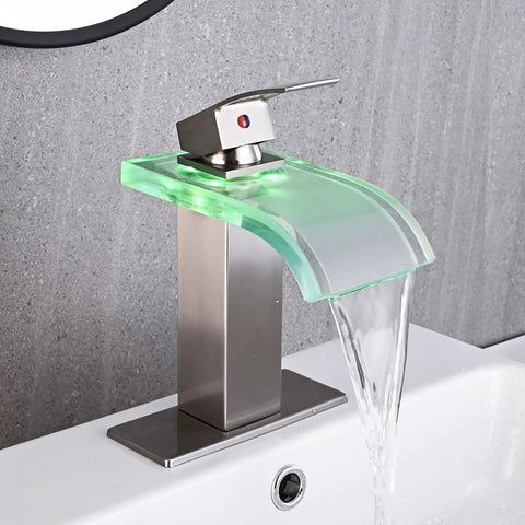 Dope LED Temperature Sensing Waterfall Vanity Faucet in Brushed Nickel with Color Changing Glow on gray wall showing water flow