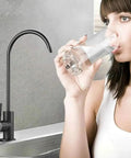 Woman drinking water from matte black drinking water faucet for home RO filtration system non air gap kitchen water purifier faucet