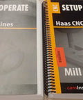 Manuals titled 'CNC Setup & Operate Haas CNC Machines,' covering lathe and mill operations on metal components.
