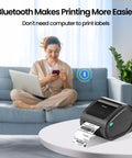 Bluetooth Thermal Shipping Label Printer For 4x6 Rolls And Wide Fan Fold Paper With Spacious Built In Storage Tray on table, printing labels.