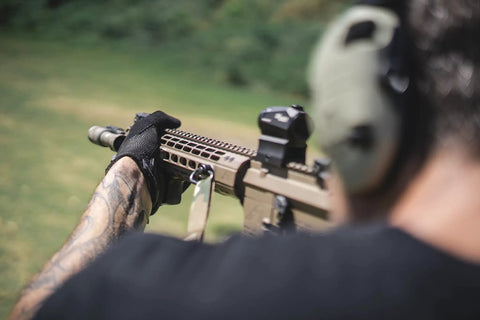 Person using a rifle outdoors wearing M-Pact 0.5mm High-Dexterity Covert Tactical Work Gloves With Touchscreen Capability, All Black, Large.