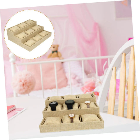 Slick Nine Grid Linen Watch Organizer Tray With Snug Padded Pillows, displaying three watches on a desk with a pink bedroom background.