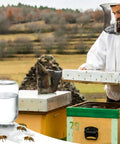 Beekeeper at a hive with Metal Bee Feeders For Honeybee Hives Entrance Feeders 4 Pack With Mason Jar Lids Water Feeders Easy Refill At The Hive