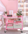 Built Tough Pink Rolling Cart Three Tier Heavy Duty Metal Utility Shelf With Smooth Rollin Wheels And Easy Grip Handle featuring floral decor and storage boxes in a stylish bedroom.