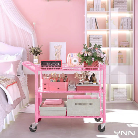 Built Tough Pink Rolling Cart Three Tier Heavy Duty Metal Utility Shelf With Smooth Rollin Wheels And Easy Grip Handle featuring floral decor and storage boxes in a stylish bedroom.