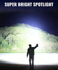 Person using Rechargeable Spotlight 2 Million Lumens Handheld Searchlight With Solar Panels For Boating Camping Hunting And Power Outages Long Range 2000 Meter Beam Beastly Bright LED Spotlight For Outdoor Emergencies illuminating a hillside at night