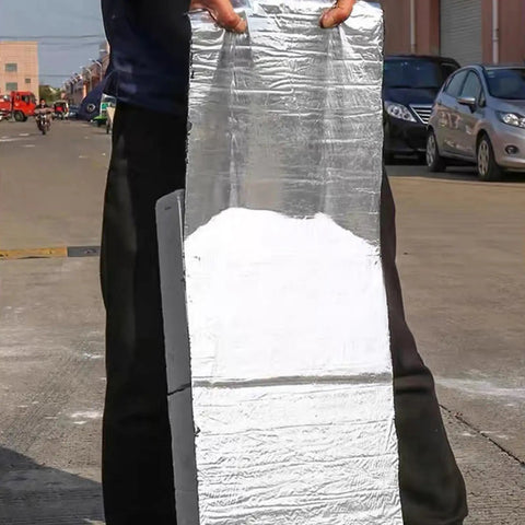 Heavy Duty Asphalt Roofing Tape That Kicks Leaks To The Curb With Heat Reflective Aluminum Foil, held upright outdoors.