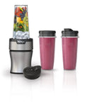 Heavy Duty Personal Blender Featuring 900W Push To Blend Motor And Pro Extractor Blades Crushing Ice For Nutrient Dense Smoothies Including Three Grab And Go 20 Oz Serveware Cups In Classic Silver with fruits and smoothies.