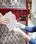 Two individuals handling a Bulk Pack Water Resistant Self Sealing Shipping Bag 25x30cm Plastic Courier Mailer in front of a gate