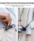Person placing CreateMate Mini SD Card Reader Case With 6-Slot Storage in pocket and hanging from camera strap, showcasing portability.