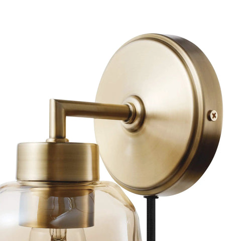 Close-up of Dope 1 Light Plug In Or Hardwire Wall Sconce In Matte Brass With Smoked Amber Glass Shade and Black Fabric Cord