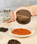 AWANSO 3-piece grinder, 2.5-inch walnut wood and aluminum, kitchen spice grinder, held over crushed red pepper.