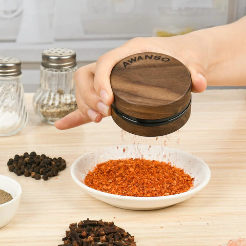 AWANSO 3-piece grinder, 2.5-inch walnut wood and aluminum, kitchen spice grinder, held over crushed red pepper.