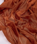 Rustic Terracotta Table Runner Hand Dyed From Breathable Cheesecloth, textured close-up showcasing warm hues and softness.