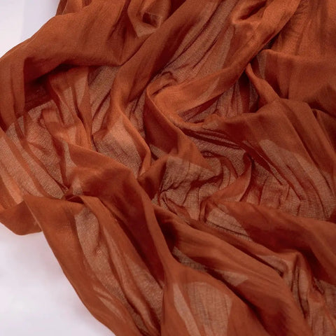 Rustic Terracotta Table Runner Hand Dyed From Breathable Cheesecloth, textured close-up showcasing warm hues and softness.