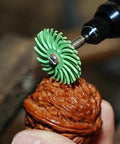 Close-up of 76 Piece 1 Inch Radial Bristle Disc Kit With One Eighth Inch Shank For DIYers Using Rotary Tools on wood surface