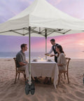 Set of Four Canopy Weights Sand Bags, Heavy Duty 420D Oxford Tent Weights on beach with canopy and dining table at sunset