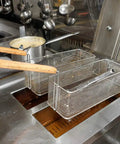 Commercial kitchen deep fryer with wire mesh baskets, heavy duty deep fryer basket cleaning brush with high temp brass bristles nearby.