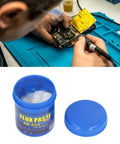 Technician using Eco Friendly Solder Paste Flux Cream for Electronics Repair 100g on PCB with open jar of flux cream nearby