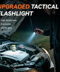 Man using upgraded tactical flashlight to illuminate engine under car hood at night, showcasing high brightness and zoom feature.