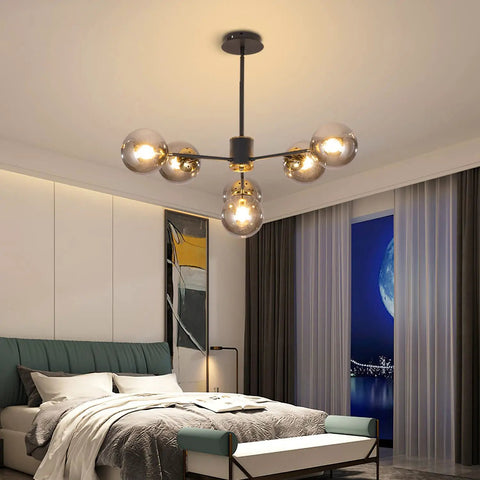 Six Light Glass Globe Sputnik Chandelier In Matte Black With Amber Shade illuminating a modern bedroom