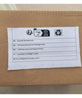 Cardboard box with multilingual assembly instructions and recycling symbols on top label