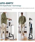 Premium Cordless Stick Vacuum With Auto Empty Base And Tangle Free Roller That Eats Up Pet Hair And Dirt Without Clogging Or Making A Mess Up To 70 Minutes Of Battery Life For Effortless Daily Home Care And Fresh Clean Floors beside a self-emptying station, demonstrating hands-free cleaning.