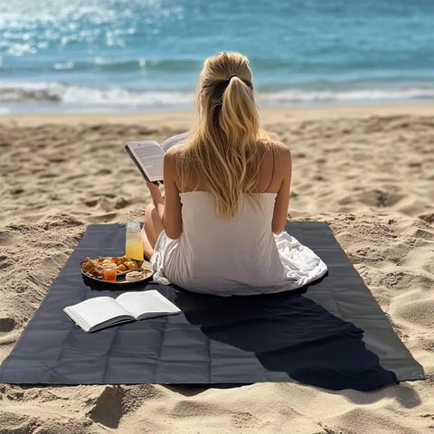 Woman reading on Ultralight 55x39 Inch Waterproof Pocket Picnic Blanket Foldable And Compact For Camping Festivals Beach Hiking