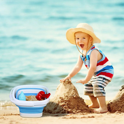 Child playing on a beach with a 2 Pack Collapsible Buckets 5L 1.3 Gallon Portable Cleaning Bins in grey and blue nearby.