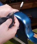 Cleaning an electric guitar body with a microfiber cloth using the Complete Guitar Care Kit And Clean Polish Set With Fretboard Conditioner.