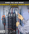Electrician using Auto Ranging Digital Clamp Meter With True RMS For AC And DC Current And Voltage Resistance tool on panel