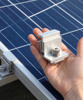 Person holding Eight Piece 35 To 50mm Adjustable Solar Panel End Clamp, showing aluminum material, beside mounted solar panels.